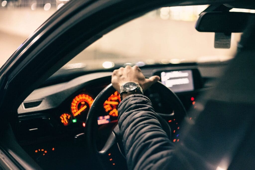 Person behind the wheel of a vehicle. Photo displays dashboard