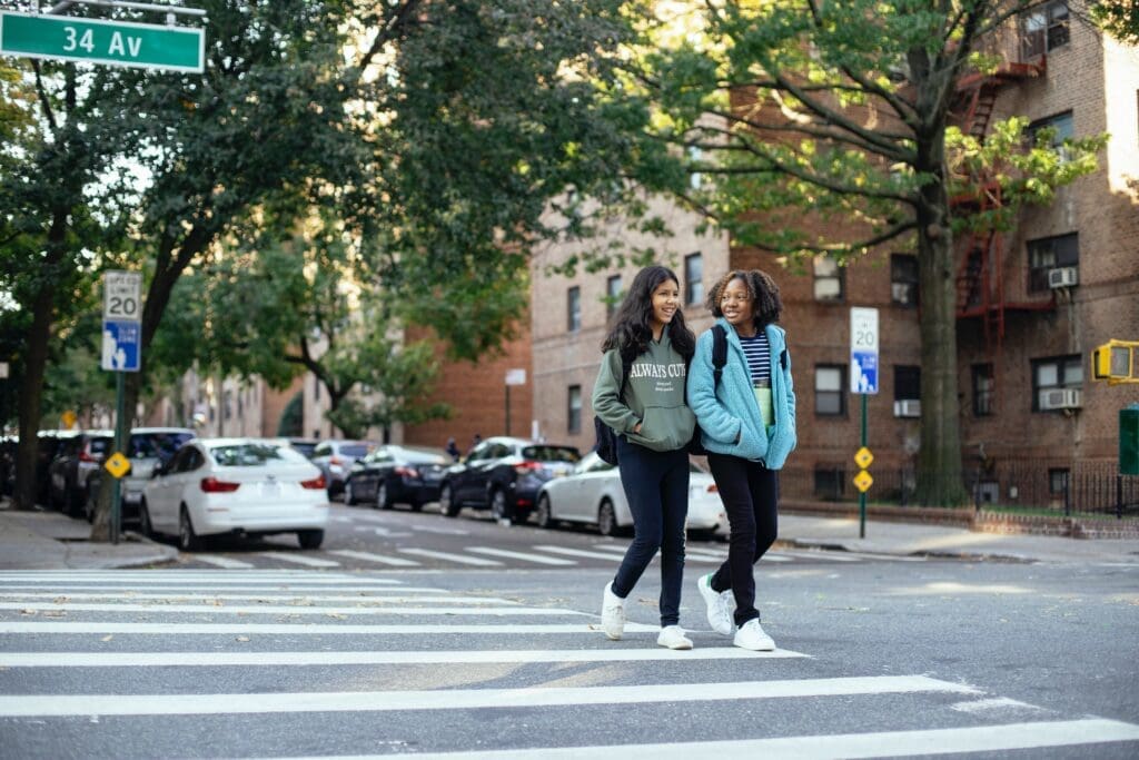 Two people crossing the street on a crosswalk