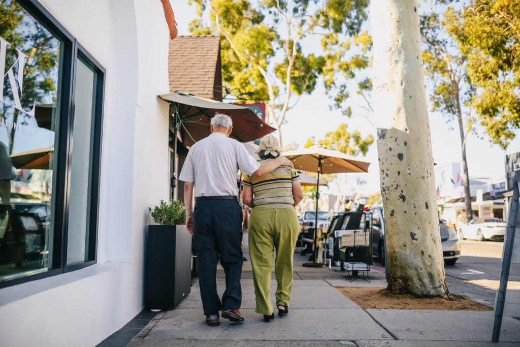 elderly couple walking on a sunny street