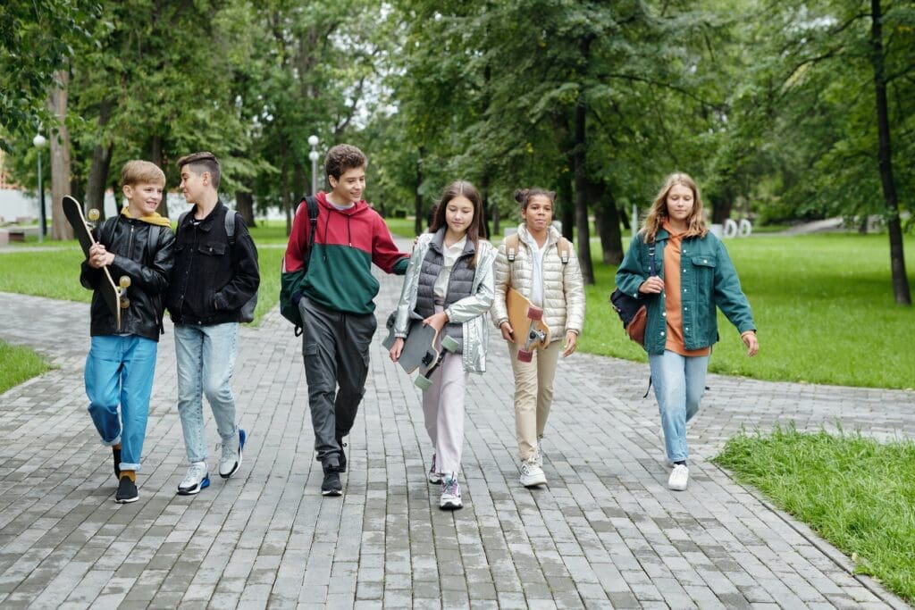 6 children are walking together across a pathway