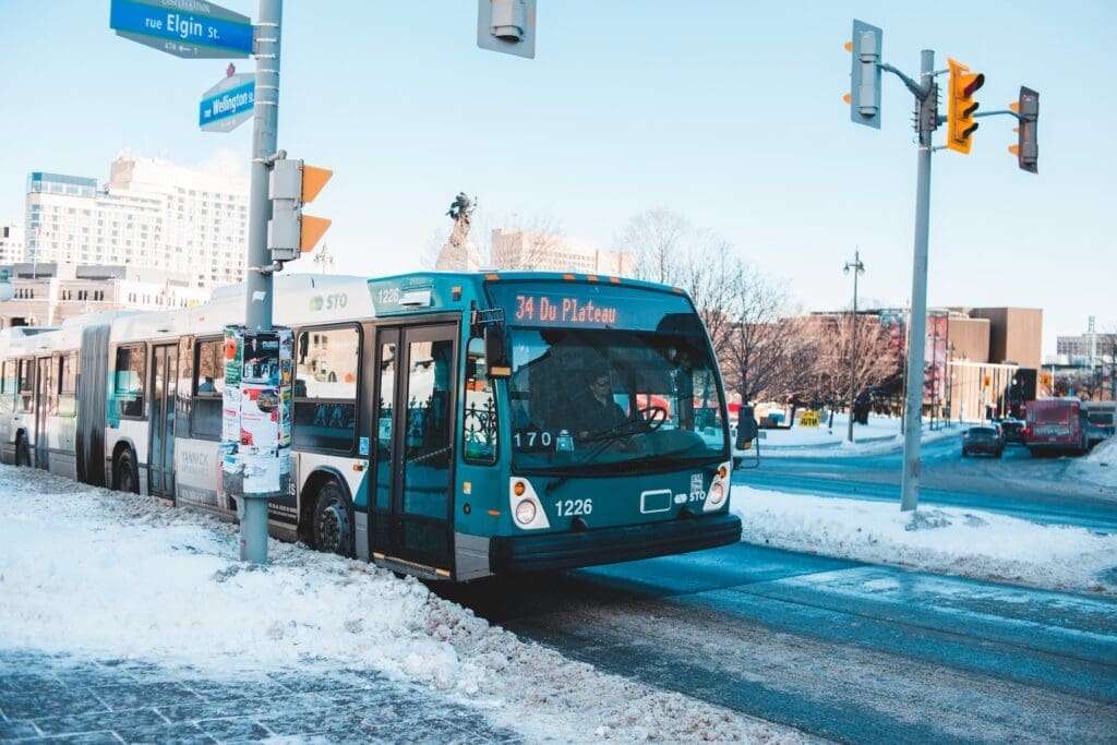 photo of a stopped public bus and a snow covered street