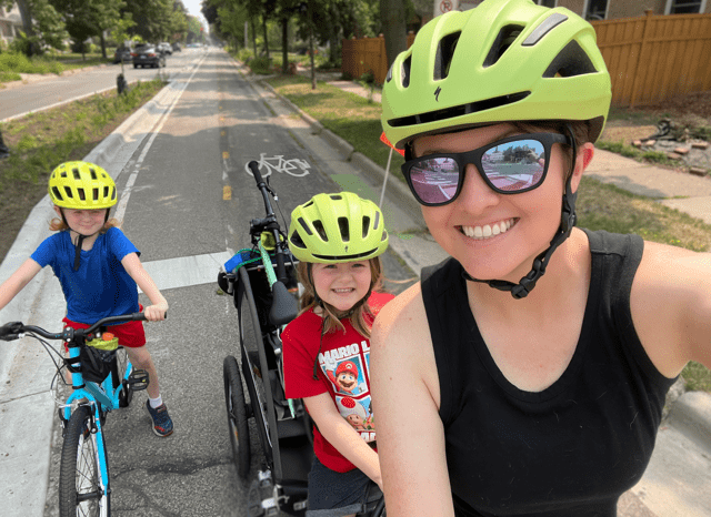 Laura Groenjes Mitchell, local walkability advocate, cycling on a bike path with children