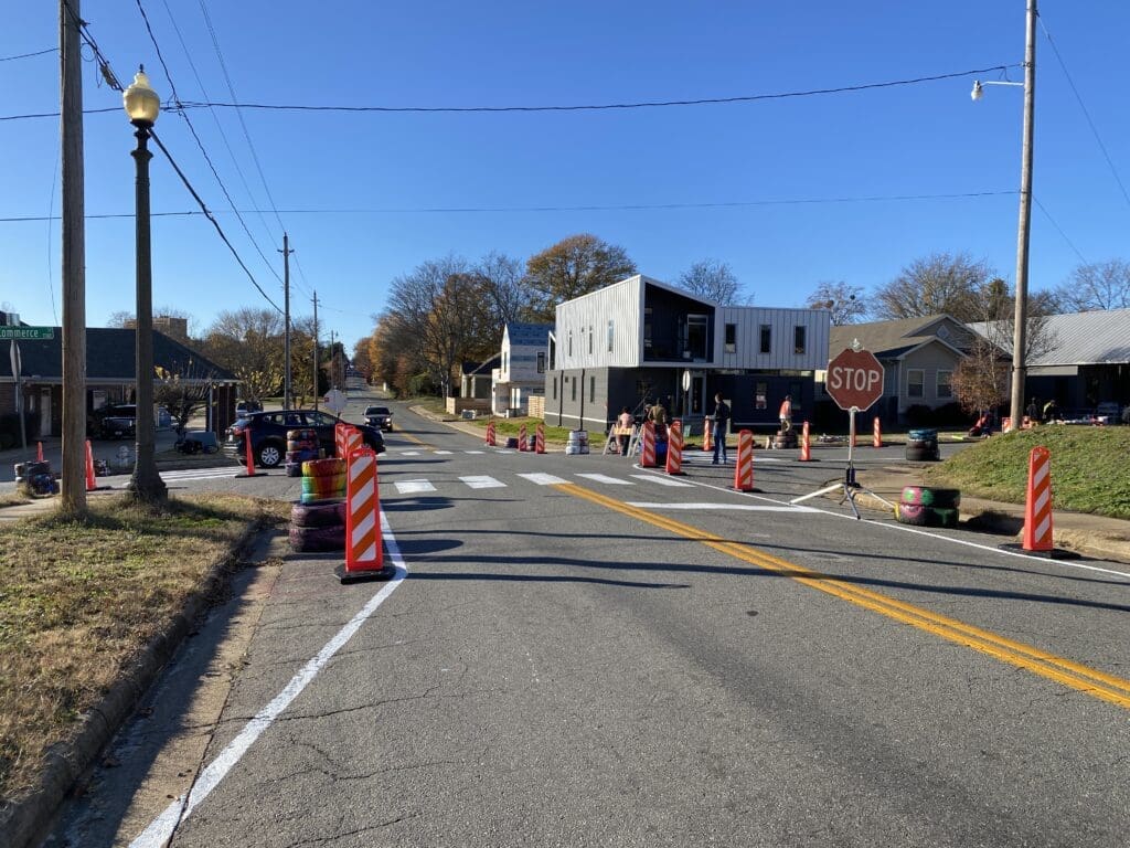 Walking College pop up pedestrian crossing project installation with narrowed road width, stop signs, and shorter marked pedestrian crossings.