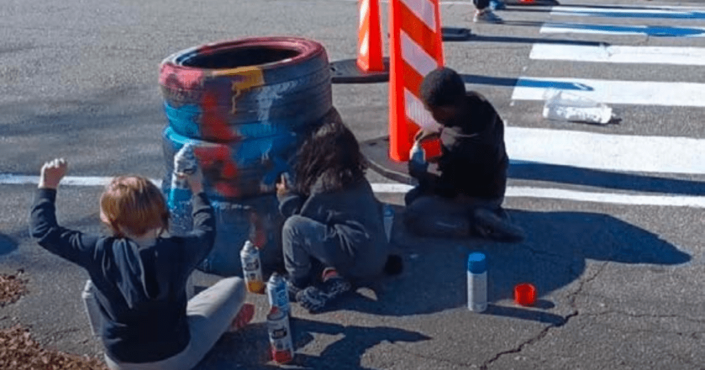children paint tires as part of a demonstration project
