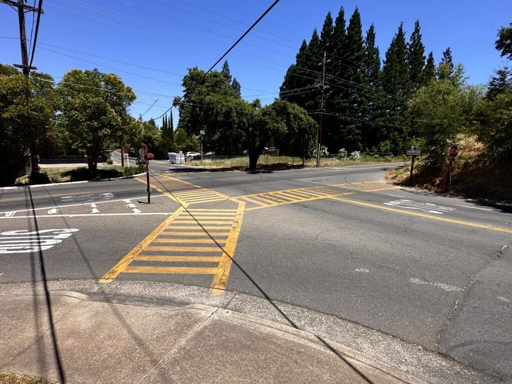 a school street crossing with a four-way stop with an additional right-hand turn lane and three crosswalks converging in the center of the intersection