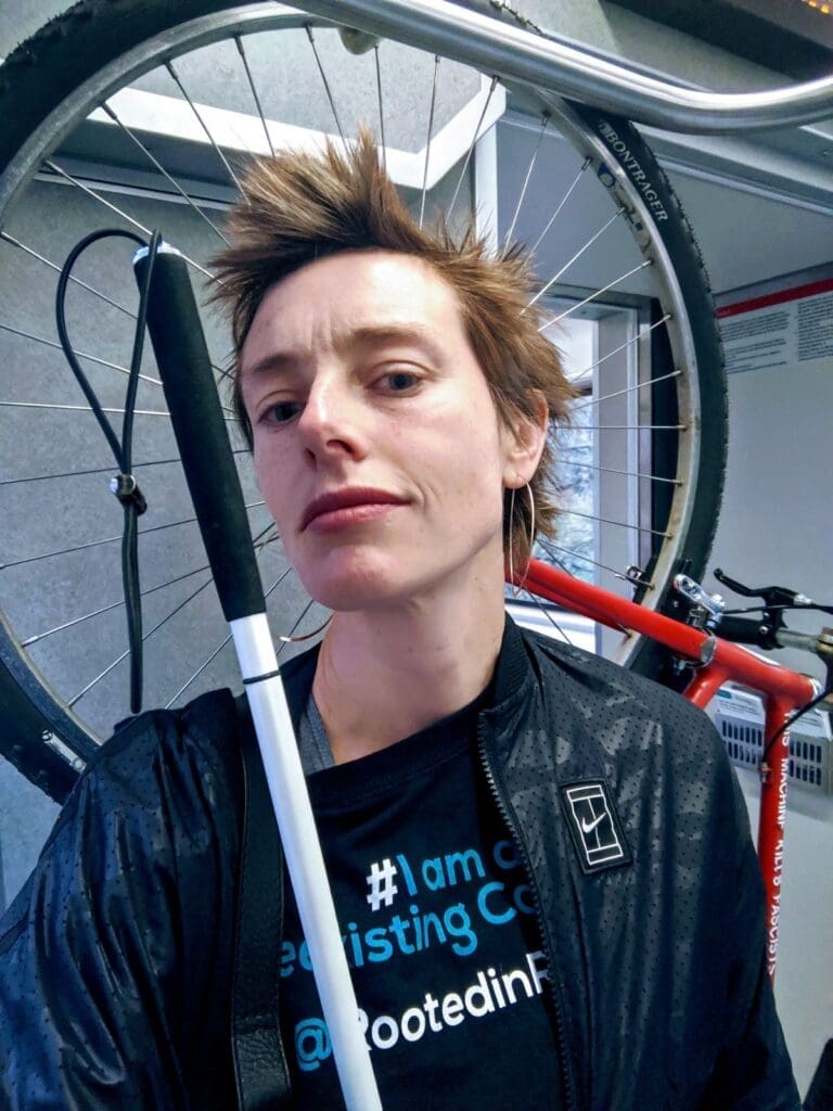 Anna Zivarts with a cane and a bike on a light rail train. (Photo by Anna Zivarts)