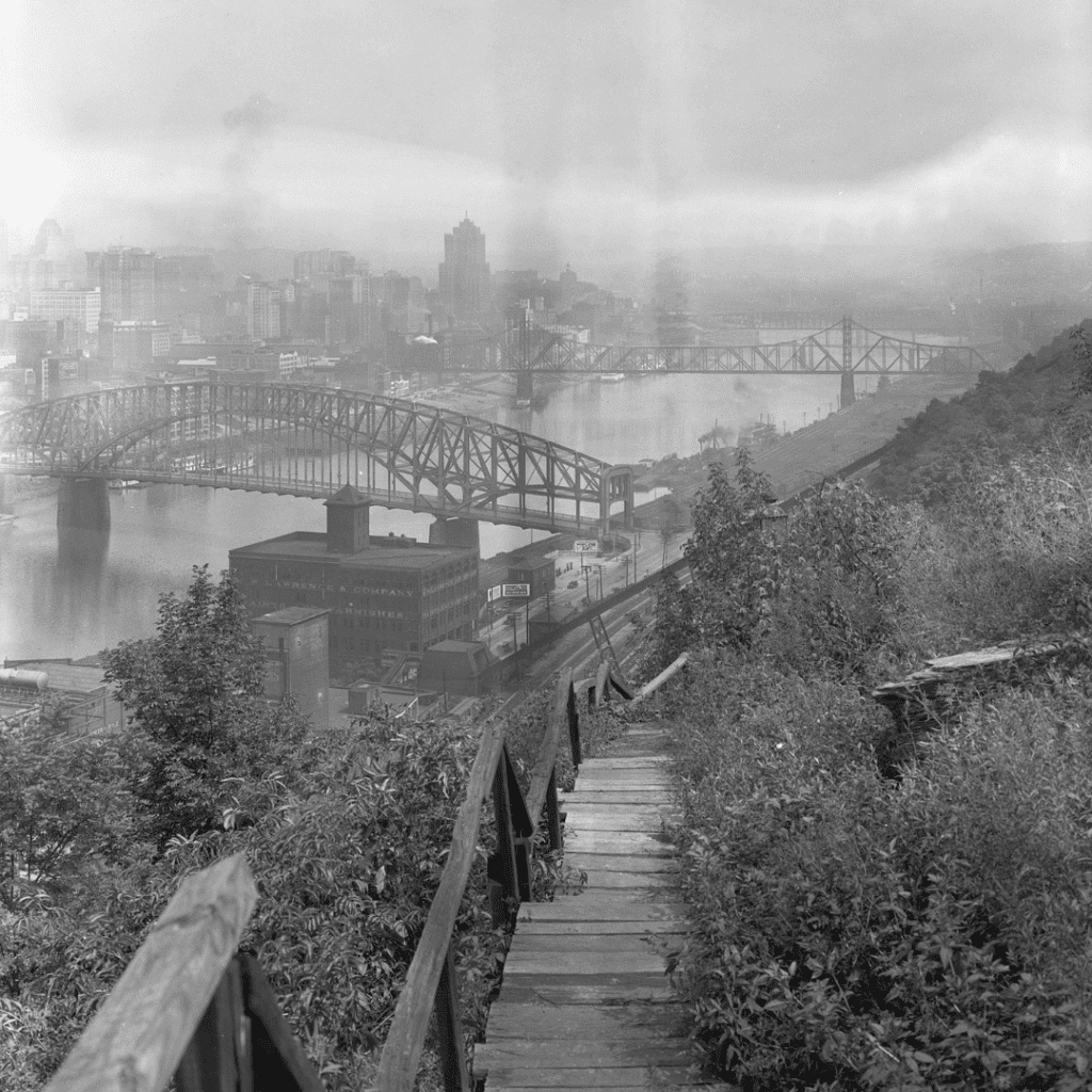 Old photograph of wooden stairs in Pittsburg, PA. The photo is full of post-industrial smoke.