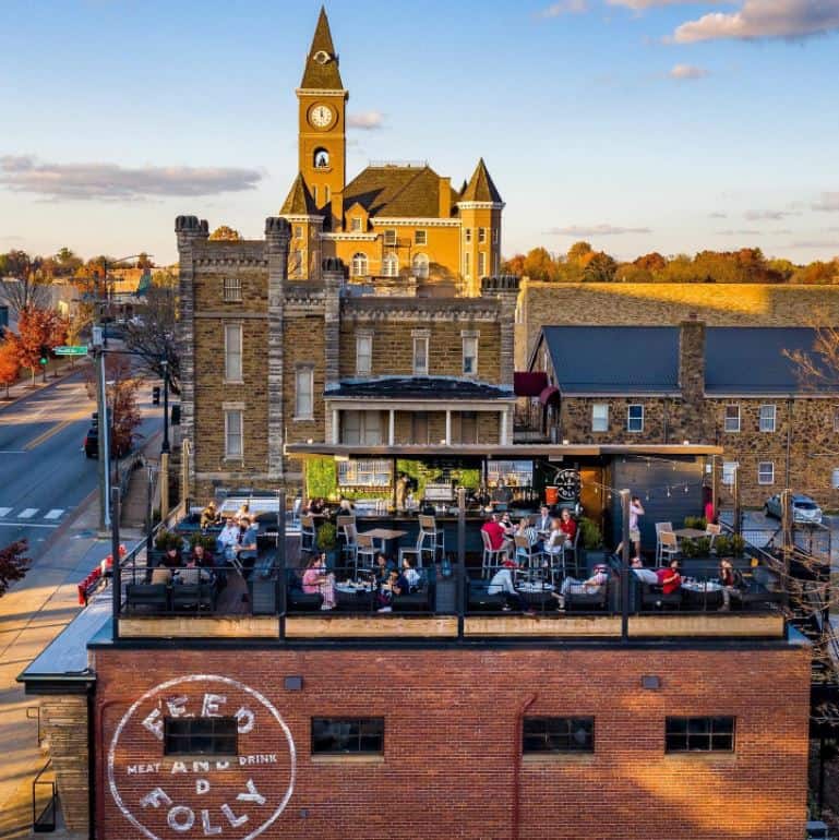 a rooftop seating area above a brick building along a walkable street